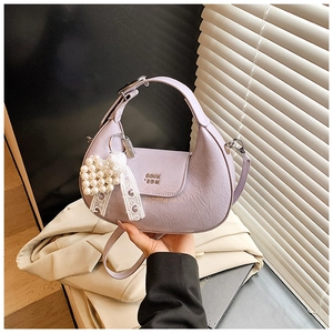 Detail of lavender dumpling handbag with pearl lace charm and metallic text