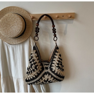 Detail of hand-woven hobo bag featuring geometric patterns and wooden bead accents