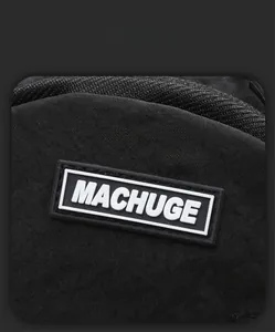 Detailed close-up of the MACHUGE rubber logo on a black water-resistant fabric chest bag