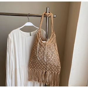 Detail of bohemian handwoven tote with cotton rope texture and long tassel fringe