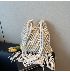 Detail of bohemian woven bucket bag featuring cotton rope mesh and wooden handle