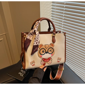 Detail of cute bear tote bag with leopard silk scarf and wide fashion strap