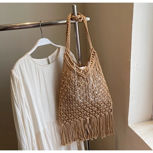 Close-up of bohemian woven tote bag with fringe details and inner drawstring pouch