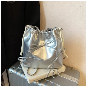 Close-up of metallic silver bucket bag with three 3D bows and chain shoulder strap