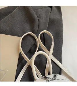 Detail of smooth white leather backpack featuring silver metal zippers and long straps