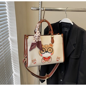 Detail of cute bear tote bag with leopard scarf and jacquard strap in white and brown