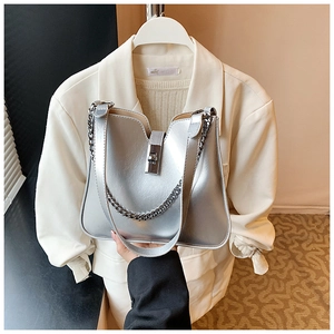 Detail of silver bucket bag showing V-shaped opening and metal chain shoulder strap