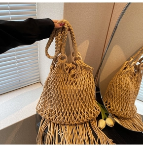 Detail of hand-woven straw shoulder bag with wooden ring handle and long tassels