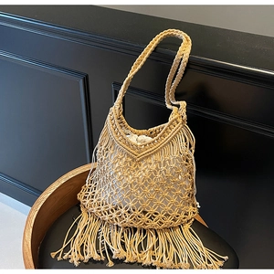 Detail of bohemian hand-woven mesh tote with hanging tassels and drawstring inner pouch