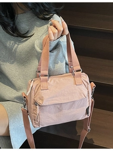 Pink nylon crossbody pillow bag with adjustable strap and front zipper for daily use