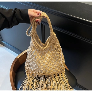 Close-up of bohemian woven tote bag showing intricate knot details and long tassel fringe