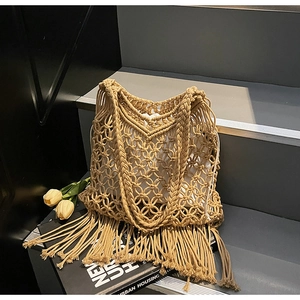 Detailed view of bohemian woven tote bag with fringe tassels and hollow knit pattern