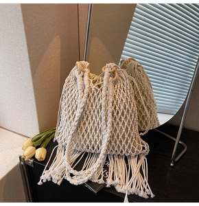 Detail of bohemian woven bucket bag with fringe tassels and wooden ring handles