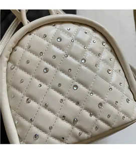 Close-up of beige quilted PU leather backpack with diamond stitching and rhinestone details
