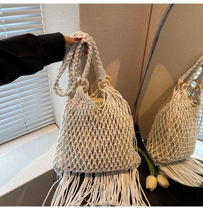 Detail of woven mesh bag with wooden ring handles and bohemian fringe accents