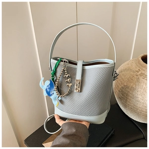 Detail of light blue bucket bag with woven texture, leather trim and elephant charm