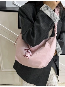 Pink crescent canvas tote bag with pleated strap and red letter print for women