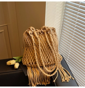 Detail of hand-woven bucket bag featuring hollow mesh pattern and long fringe tassels