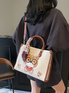 White leather tote bag with cartoon bear pattern and leopard scarf on model