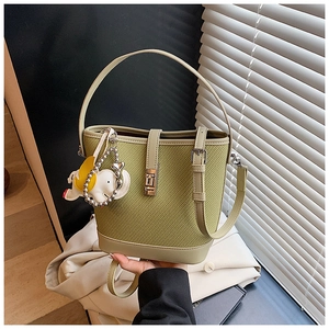 Detail of green bucket bag with textured fabric, leather trim and cute elephant charm
