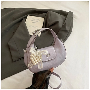 Detail of lavender wrinkled leather handbag with pearl heart charm and metal logo