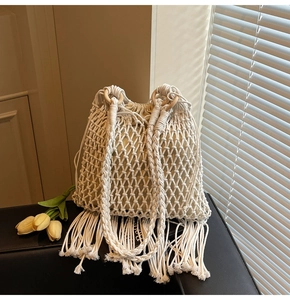 Detailed macro of handmade macrame bucket bag with fringe and wooden handles