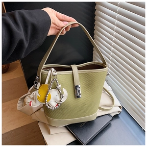 Detail of avocado green bucket bag with elephant charm and silver metal lock closure