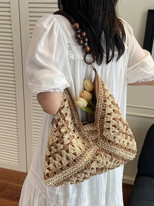 Bohemian woven straw tote bag with decorative wooden beads for summer beach travel