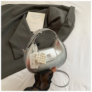 Silver crescent bag with metallic crinkle texture, pearl heart charm and lace bow