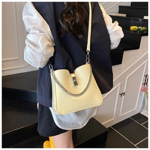 Detail of cream bucket bag showing silver chain, clasp and smooth faux leather texture