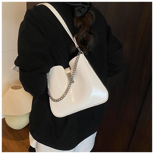 Detailansicht der weißen Lackleder-Schultertasche mit Metallkette und Lederriemen