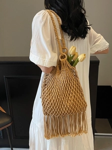 Handmade khaki macrame bucket bag with fringe tassels and wooden ring shoulder strap
