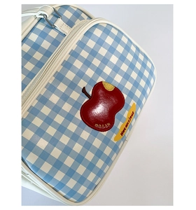 Close-up of blue gingham tote bag with red apple embroidery and adjustable strap
