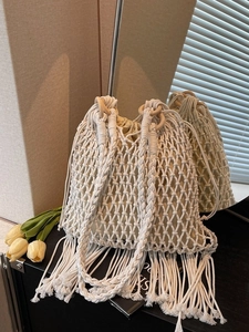 Bohemian cream woven bucket bag with wooden ring handles and long fringe details