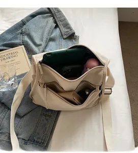 Spacious interior of a canvas crossbody bag with compartments for tablet and essentials