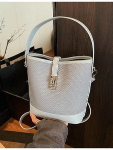 Chic woven light blue bucket bag with leather accents and elegant metal turn-lock closure