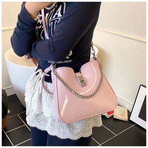 Detail of light pink patent leather bucket bag with silver metal chain and push-lock