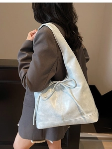Sac fourre-tout bleu clair avec nœud ruban porté à l'épaule pour un style décontracté
