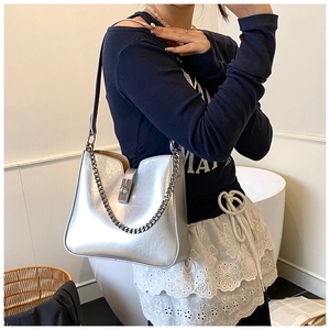 Detail der silbernen Metallic-Beuteltasche mit Kette und quadratischem Metallverschluss