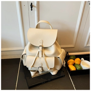 Close-up of cream lychee texture leather backpack with flap drawstring and buckle details