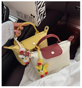 Detail of mini nylon handbags with leather handles and cute yellow duck charms
