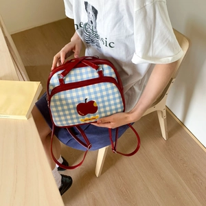 Detail of blue and white checkered backpack with red trim and Not anxious apple print