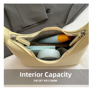 Dettaglio dell'interno della borsa hobo in pelle beige con cosmetici per uso quotidiano
