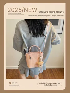 Borsa a secchiello in pelle rosa con ciondolo a orsetto e dettagli argentati su modella