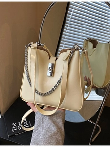 Elegant cream yellow bucket bag with silver chain and metal twist lock detail