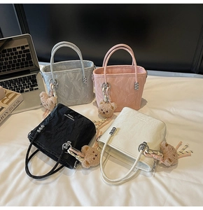 Detail of four colorful bucket bags with unique cloud-like pleats and plush bear charms