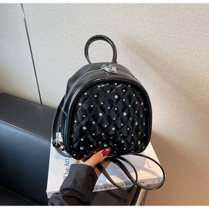 Detail showing quilted rhombus pattern and silver metal rivets on black leather backpack