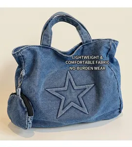 Close-up of blue denim tote bag with stitched star pattern and small zipper coin purse