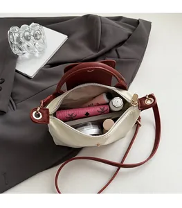 Top view of two-tone crossbody bag interior showing spacious compartments and zip pocket