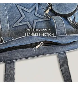 Detail of smooth metal zipper on blue denim tote bag with star embroidery accents